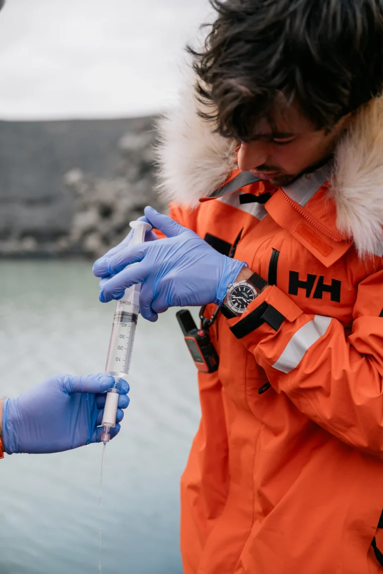 "A scientist uses a syringe to filter bacterial samples from meltwater