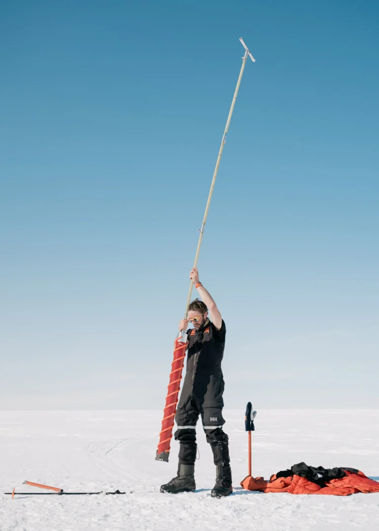 Researcher holding ice corer on glacier