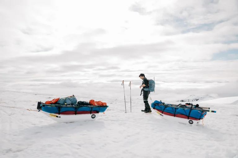 A men next to two sleds