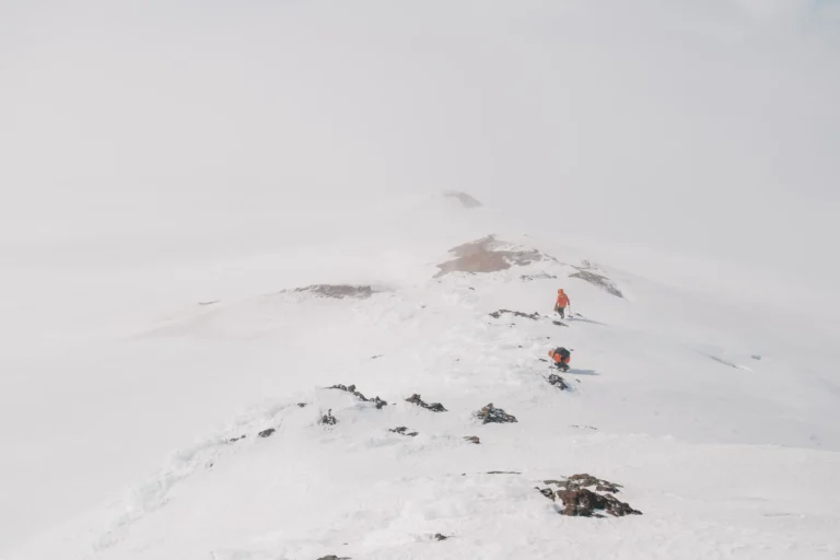 Man in orange working across a mountain